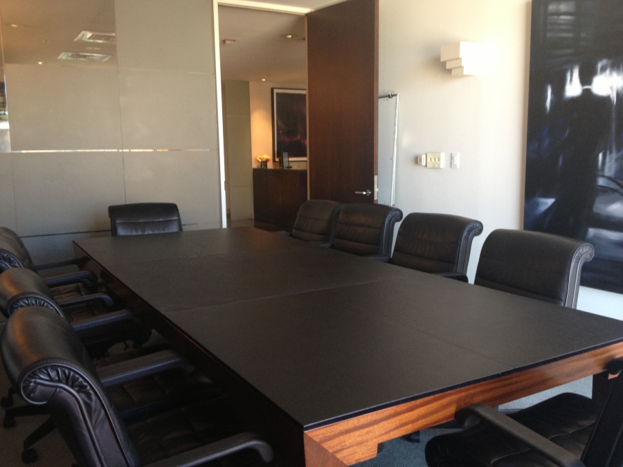 Black on black table pads covering a rectangular conference table.